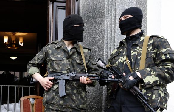 Hai tay súng ủng hộ Nga đang canh gác trước cửa trụ sở chính phủ khu vực Luhansk, đông Ukraine