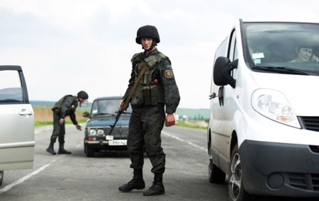 Binh sĩ Ukraine khám xét xe cộ tại một chốt kiểm soát bên ngoài thành phố Slovyansk