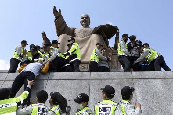 Cảnh sát Hàn Quốc ngăn cản nhiều sinh viên đại học trèo lên bức tượng Vua Sejong để biểu tình chống lại Tổng thống Park Geun-hye