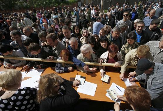 Người dân xếp hàng nhận phiếu bầu từ các thành viên ủy ban bầu cử địa phương tại Donetsk