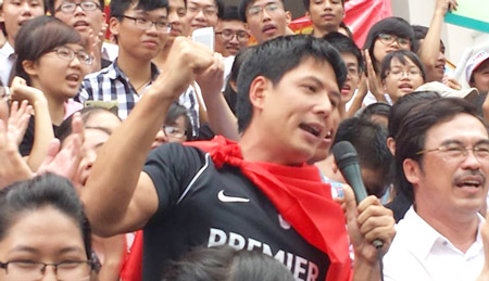 Bình Minh cầm micro bắt nhịp bài Quốc ca cho đoàn người tuần hành phản đối Trung Quốc cùng hát theo