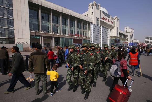 Các lực lượng cảnh sát có vũ trang đang tuần tra gần cửa ra vào Ga tàu điện phía Nam của thành phố Urumqi