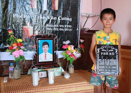 Em trai út của nạn nhân Trần Văn Cường bên di ảnh của anh trai