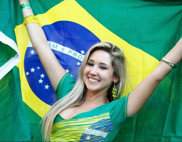 Một fan hâm mộ xinh đẹp hân hoan cầm quốc kỳ Brazil cổ vũ tại lễ khai mạc World Cup 2014