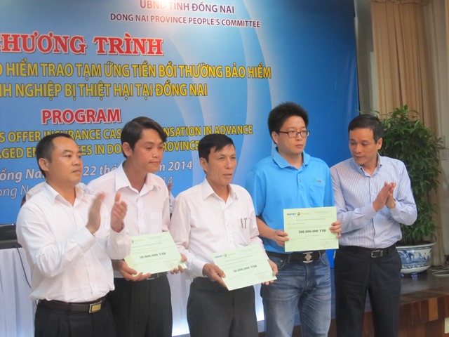 Ông Nguyễn Quang Phi - Phó Tổng giám đốc Bảo hiểm Bảo Việt trao tiền bồi thường cho các doanh nghiệp tại Đồng Nai