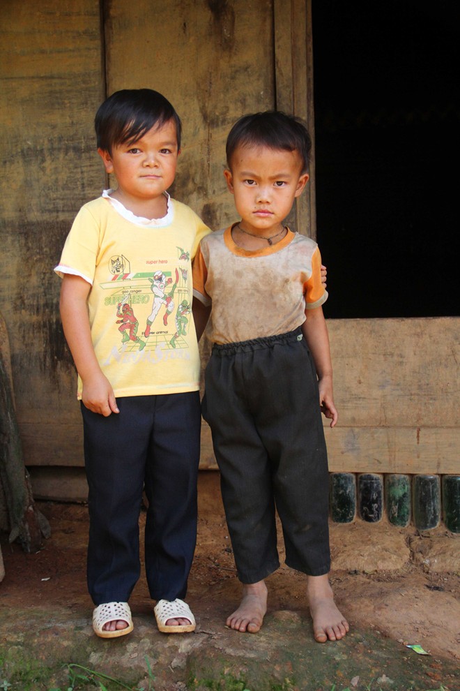 Em Sùng A Dì (trái), ở bản Hồ Nhì Pá, xã Lao Chải, huyện Mù Cang Chải (Yên Bái). Do mắc bệnh liệt tuyến Yên bẩm sinh nên chàng trai sinh năm 1995 này chỉ cao 90 cm, nặng 16 kg. Trong ảnh, Dì đang đứng cạnh người em ruột 3 tuổi của mình.