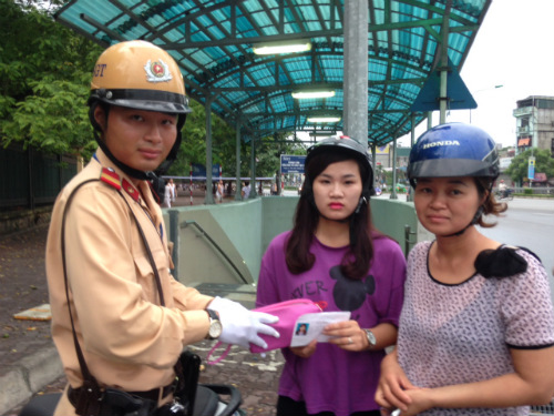 Thượng sỹ Nguyễn Mạnh Tùng (Đội CSGT số 14) trả lại tiền và giấy tờ thí sinh Lê Thị Lê Na tại cổng trường