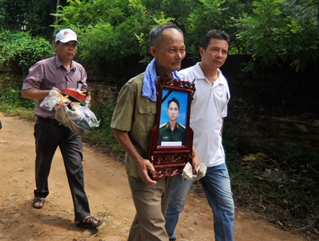 Lặng lẽ ôm di ảnh của con trai, trung úy Nguyễn Văn Hưng, ông Nguyễn Văn Hắc không nói nên lời bởi đã quá đau đớn trước sự mất mát này.