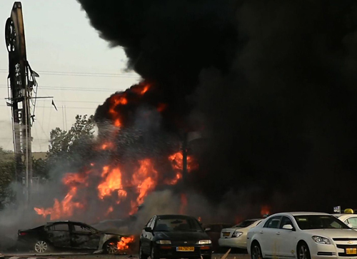 Một trạm xăng Israel bốc cháy do trúng rốc két của Hamas. Ảnh: AFP 