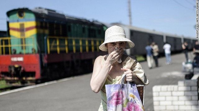 Một phụ nữ bịt mũi và miệng khi đi qua nhà ga để tránh mùi bốc ra từ các toa tàu chở xác. Ảnh: CNN