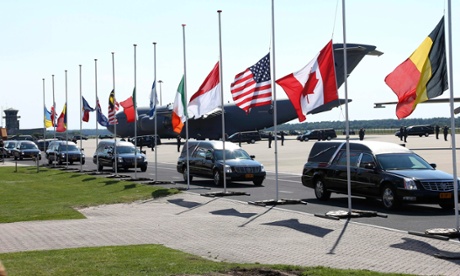 The convoy with the remains of the victims of Malaysia Airlines MH17 downed over rebel-held territory in eastern Ukraine, drives past international flags as it leaves Eindhoven airport.