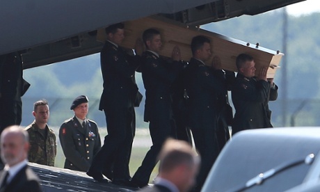 Một quan tài đựng thi thể nạn nhân MH17 đang được chuyển xuống từ máy bay trong một buổi lễ đón tiếp theo nghi lễ quốc gia tại Eindhoven. Ảnh: Reuters