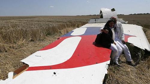 Hai vợ chồng già ngồi trên chiếc cánh máy bay còn sót lại của MH17