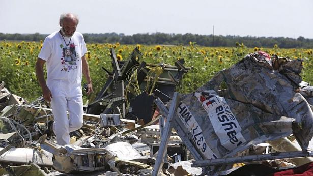 Người bố George Dyczynski mặc chiếc áo phông in hình con gái, đứng trước đống đổ nát của MH17