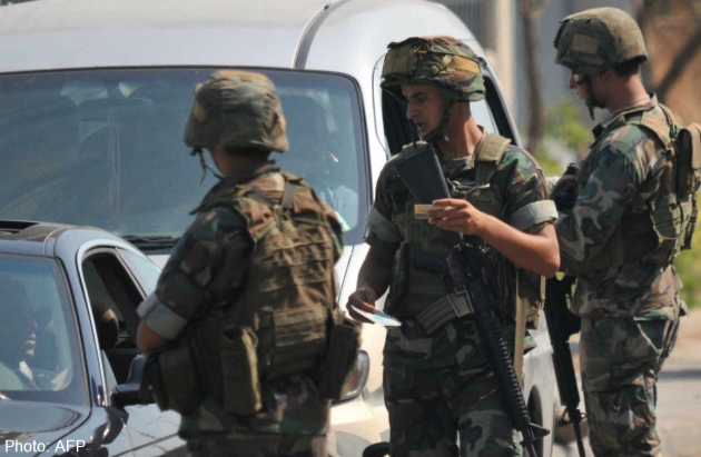 Binh lính Li-băng kiểm tra chứng minh thư của các tài xế tại một chốt kiểm soát ở thành bố Tripoli