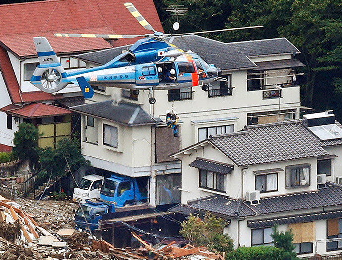 Một cư dân địa phương được một máy bay trực thăng cứu hộ từ một khu vực nơi một vụ lở đất quét qua. Ảnh: Reuters/Kyodo