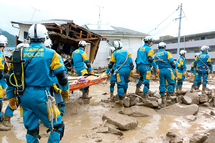 Một đơn vị cứu hộ của cảnh sát tới hiện trường để tìm kiếm những người còn mắc kẹt trong đất lở. Ảnh: Reuters/Kyodo