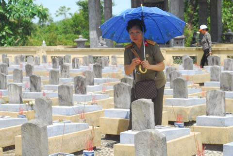 Bà Đỗ Thị Hiên bên cạnh ngôi mộ của người cậu là liệt sĩ Ngô Công Chức.