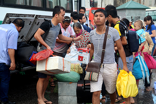 Sau chuyến đi dài mệt mỏi, người dân vội vã xuống xe lấy hành lý.