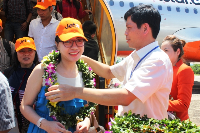 Ông Lê Anh Tuấn - PCT UBND tỉnh Thanh Hóa đang tặng hoa và chúc mừng những hành khách của JetstarPacific đầu tiên tại sân bay Thọ Xuân