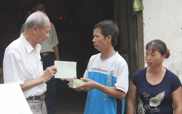 Ông Đoàn Văn Đạt trao hỗ trợ 50 triệu tiền mặt và sổ tiết kiệm trị giá 50 triệu đồng để ông Chấn giải quyết khó khăn