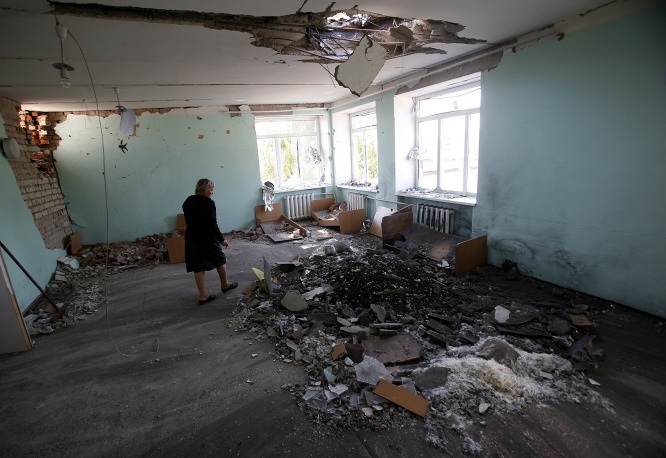 Một giáo viên Ukraine chán nản nhìn nhà trẻ nơi cô làm việc bị bom tàn phá 