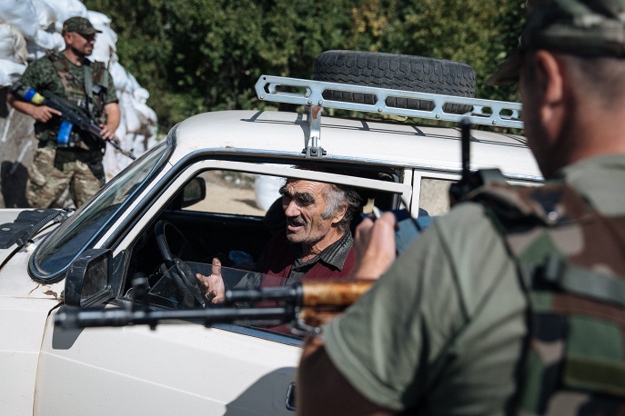 Một người đàn ông dừng xe tại trạm kiểm soát của lực lượng chính phủ