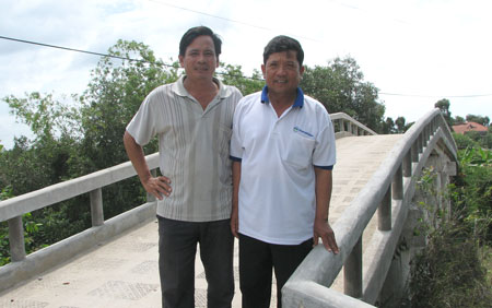 Ông Bé (bên phải) cùng với Trưởng ấp Cầu Lớn bên cây cầu bê tông vừa xây xong