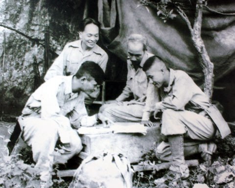 Chủ tịch Hồ Chí Minh, đại tướng Võ Nguyên Giáp cùng trung đoàn trưởng Thái Dũng và tiểu đoàn trưởng Dũng Mã đang nghiên cứu sơ đồ tác chiến trong chiến dịch Biên Giới 1950.