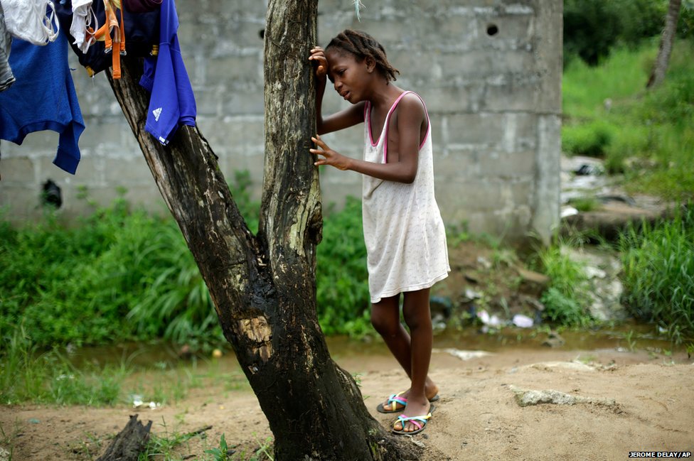 Cậu bé 9 tuổi Mercy Kennedy khóc nức nở khi các nhà hoạt động đến thăm nhà cô bé tại Monrovia, Liberia. Bức hình được chụp 1 ngày sau khi mẹ cô bé qua đời vì Ebola