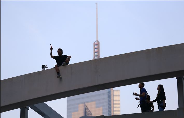 Người đàn ông tên Yau trèo lên mái cầu vượt dọa nhảy xuống nếu người biểu tình không rút lui