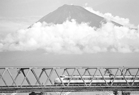 Đoàn tàu Shinkansen chạy ngang cây cầu trên sông Fuji phìa Tây Tokyo với ngọn núi Phú Sĩ đàng xa.