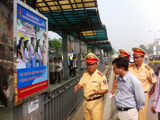 Đại tá Đào Vịnh Thắng đang giải thích bức ảnh tuyên truyền đội MBH tại điểm trung chuyển xe buýt Long Biên (Hà Nội)
