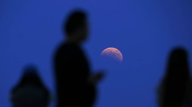 Người dân ngắm cảnh tượng thiên văn kỳ thú và hiếm hoi tại một sân tennis ở thành phố Thượng Hải, Trung Quốc. Ảnh: Reuters