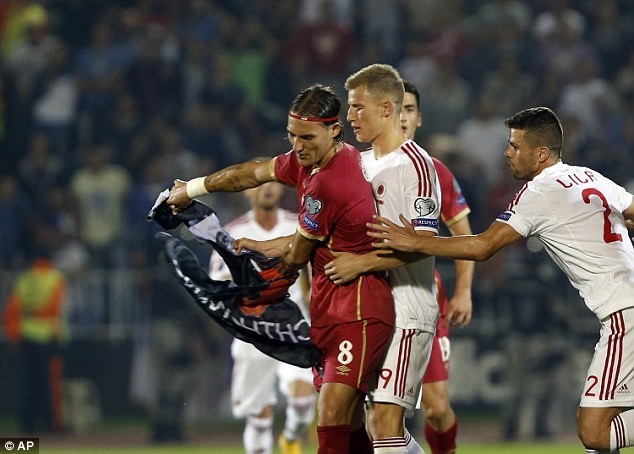 Cầu thủ hai đội tranh nhau lá cờ Albania