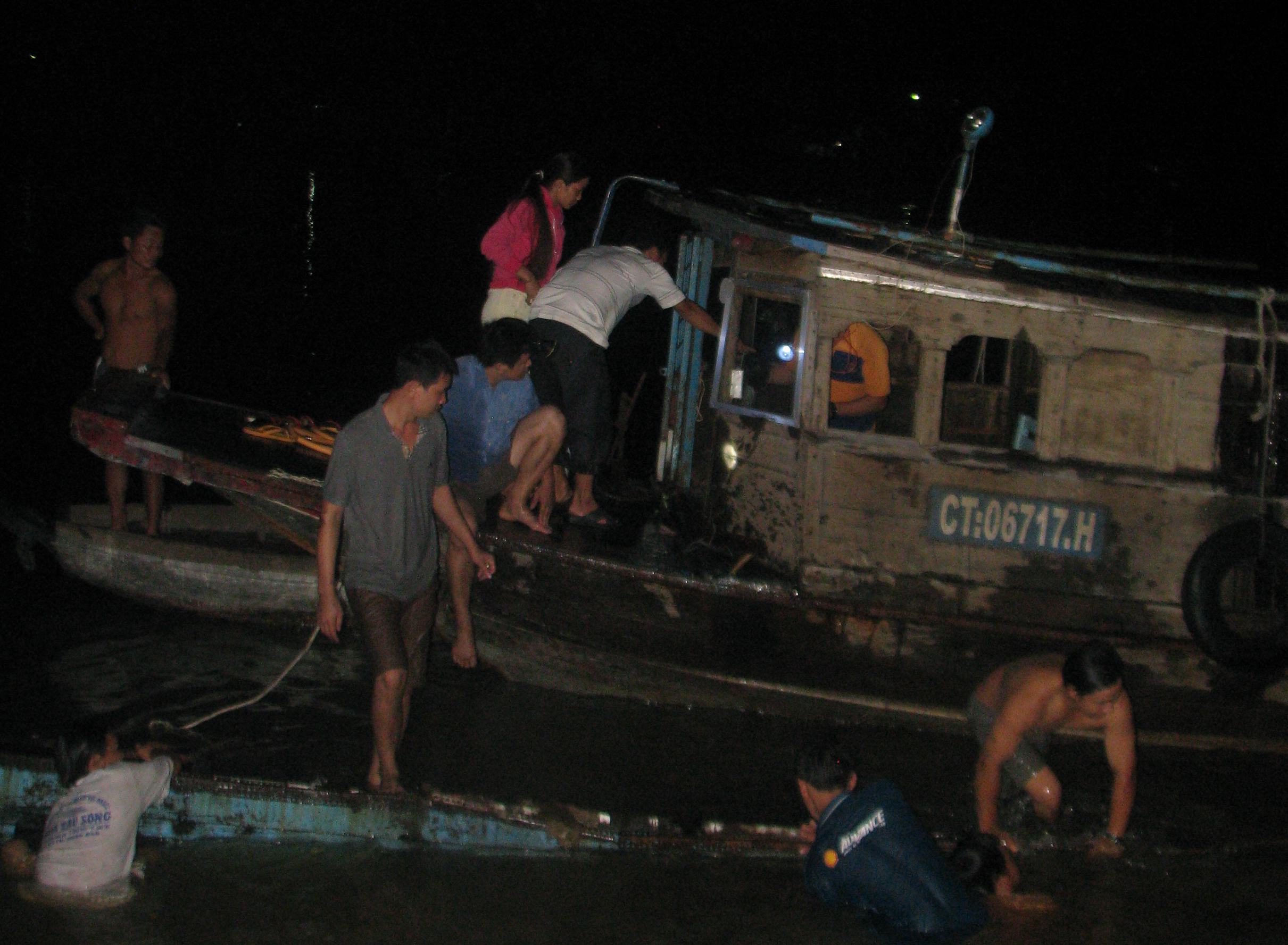 Dù đêm khuya, nhiều người dân vẫn giúp chủ ghe bị chìm lặn vớt hàng hóa đưa lên bờ
