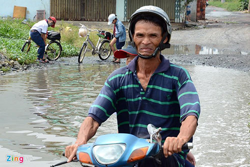 Ngay cả với người lớn thì việc vượt qua đoạn đường ngập đến gần nửa thân xe máy cũng là một nhiệm vụ khó khăn.