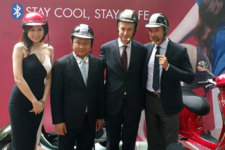 Ông Khuất Việt Hùng (thứ 2 bên trái), Phó Chủ tịch chuyên trách Ủy ban An toàn giao thông quốc gia sử dụng thử mũ bảo hiểm tích hợp tai nghe không dây do Piaggio Việt Nam sản xuất - Ảnh: Bobi 