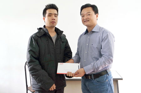 Tổng Biên tập Nguyễn Bá Kiên trao quà cho anh Đặng Quang Vinh