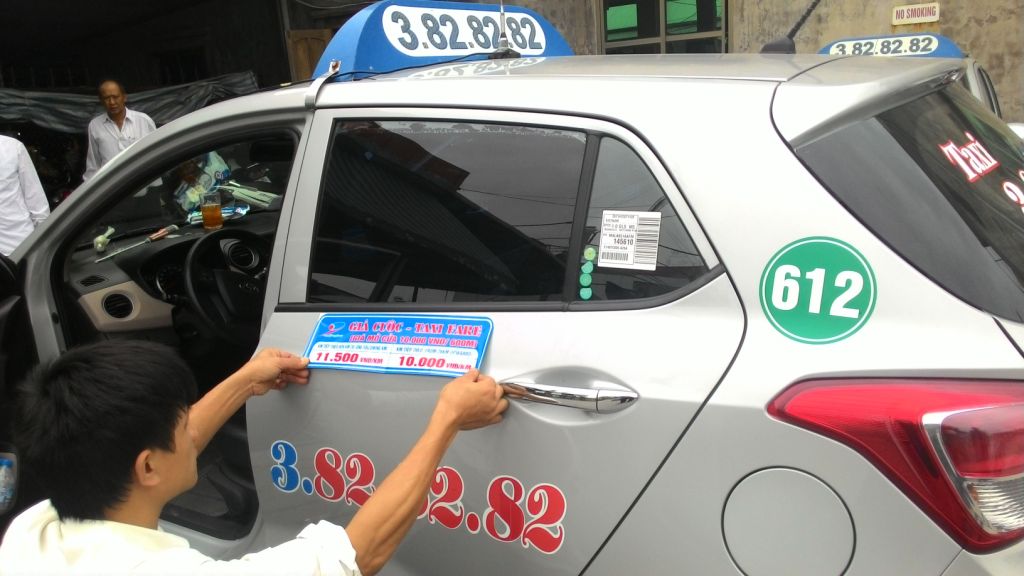 Nhân viên taxi Đất Cảng dán bảng giá cước mới