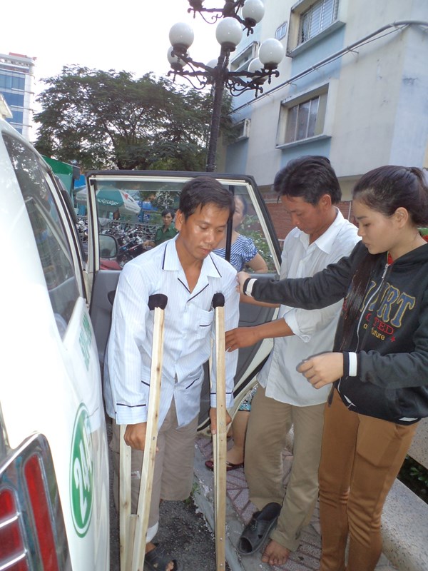 Anh Nam bước xuống xe trên chiếc nạng gỗ để vào Bệnh viện Nhi đồng 1 thăm con trai sống sót kỳ diệu của mình. 