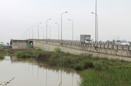 Cây cầu vượt “vô danh” (trái) bị cắt đầu bỏ đuôi nằm ẩn sau cây cầu vượt nút giao Tỉnh lộ 80 (Quốc Oai - Hà Nội)