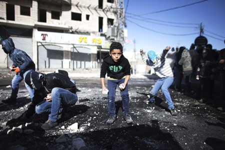 Thanh niên Palestine ném đá về phía cảnh sát biên giới Israel trong cuộc đụng độ tại một trạm kiểm soát giữa các trại tị nạn Shuafat và Jerusalem