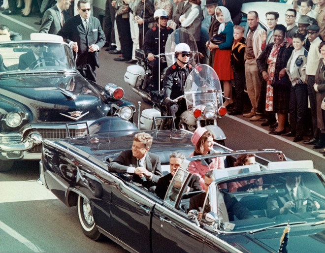 Tổng thống Kennedy và phu nhân cười tươi với người dân đứng xung quanh đường chào đón họ ở Dallas, Texas ngày 22/11/1963. Chỉ sau đó vài phút, khi đoàn xe đi ngang Dealey Plaza, một tay súng đã ám sát Tổng thống Kennedy.
