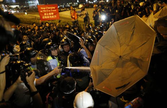 Người biểu tình trang bị ô dù, mũ bảo hiểm và nước phòng trường hợp cảnh sát xịt hơi cay