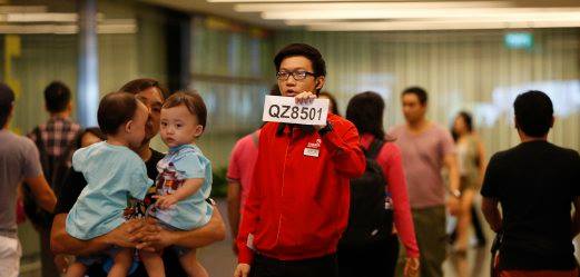 Nhân viên sân bay Changi cầm biển tiếp đón thân nhân