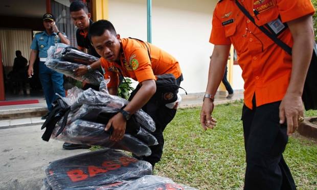 Các nhân viên tìm kiếm cứu hộ đang chuẩn bị túi đựng thi thể để đưa ra Kalimantan