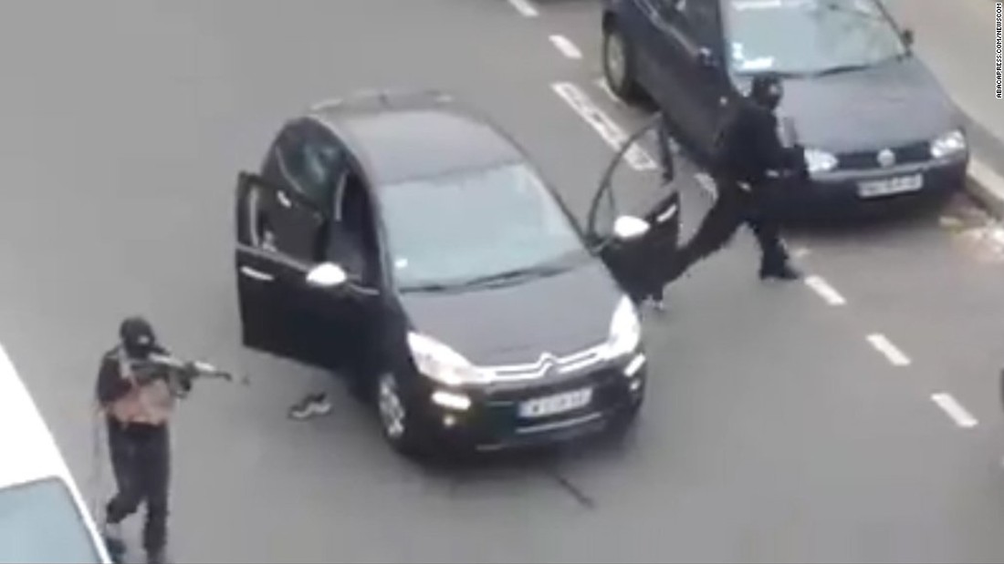 Các tay súng bước ra khỏi một chiếc xe hơi để bắn và giết chết một sĩ quan cảnh sát có mặt gần trụ sở Charlie Hebdo