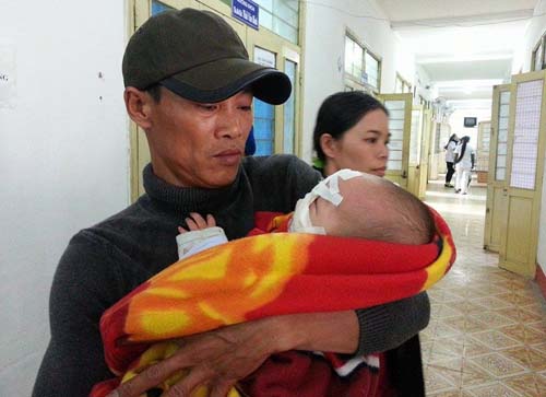 Em bé 6 tháng tuổi đang được người thân chăm sóc tại Bệnh viện sản nhi Nghệ An.