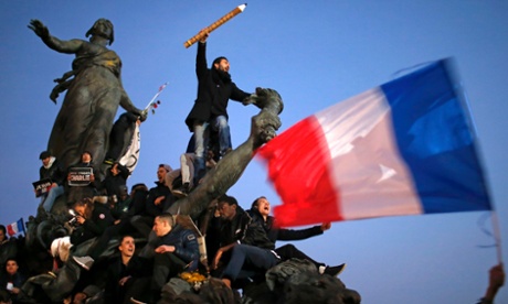 Một người đàn ông nắm giữ một cây bút chì khổng lồ trên cao trong các cuộc biểu tình ở Paris. Ảnh: Stephane Mahe / Reuters